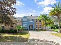 Inviting two-story home featuring brick accents, a paver driveway, and lush landscaping at 3234 Cypress Grove Dr, Eustis, FL 32736