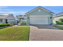 Charming single-story home features brick driveway, manicured lawn, and welcoming facade at 341 Silver Maple Rd, Groveland, FL 34736