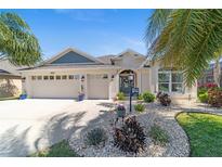 Beautiful single-story home boasts lush landscaping, a well-manicured lawn, and a spacious three-car garage at 5835 Hensley Ave, The Villages, FL 32163