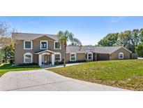 Two-story home with a well-manicured lawn and a concrete driveway, offering a welcoming curb appeal at 16109 Hillside Cir, Montverde, FL 34756