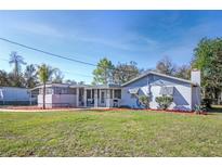 Charming single-story home with a well-maintained lawn and inviting covered entryway and a lovely, comfortable porch at 19050 Nfs-573, Altoona, FL 32702