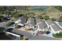 A beautiful aerial view of charming single-story homes, with a golf course and pond in the background at 2238 Pilar Pl, The Villages, FL 32162