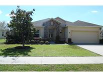 Charming single-story home with a well-manicured lawn and stone accents on the entryway at 31715 Parkdale Dr, Leesburg, FL 34748