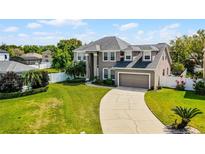 Beautiful two-story home with a well-manicured lawn and a spacious driveway leading to an attached two-car garage at 342 Lake Amberleigh Dr, Winter Garden, FL 34787