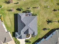 An aerial view of a well maintained home, screened lanai, and beautiful yard and landscaping at 4419 Clear Brook Ct, Leesburg, FL 34748