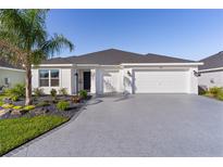 Beautiful single-story home with a well-manicured lawn and a three-car garage at 4521 Whittingtin Circle, The Villages, FL 32163