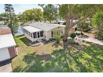 Charming home featuring screened porch, mature landscaping, and a tranquil waterfront view at 756 Heathrow Ave, The Villages, FL 32159