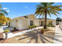 Inviting single-story home with well-maintained landscaping, including a palm tree and decorative stone accents at 8850 Se 167Th Mayfield Pl, The Villages, FL 32162