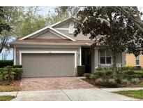 Charming single-story home with a two-car garage, manicured landscaping, and a welcoming entrance at 155 Crepe Myrtle Dr, Groveland, FL 34736