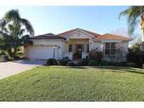 Charming single-story home with well-manicured lawn, mature landscaping, and inviting entrance at 1721 Carrera Dr, The Villages, FL 32159