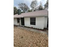 Charming single-story home with a white exterior, small garden, and walkway leading to the front door at 1903 Lake Ella Rd, Fruitland Park, FL 34731