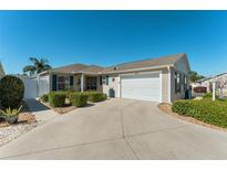 Charming home featuring well-manicured landscaping, a spacious driveway, and a welcoming two-car garage at 2330 Camden Ter, The Villages, FL 32162