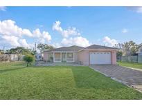 Charming single-story home boasts a well-manicured lawn and a quaint front porch, plus a two car garage and driveway at 910 Rich Dr, Mount Dora, FL 32757