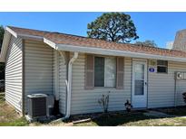 Charming single-story home featuring vinyl siding, a brown roof, and an efficient cooling system at 10301 Us Highway 27 # 84, Clermont, FL 34711