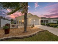 Charming one-story home with a landscaped front yard and inviting curb appeal at dusk at 1651 Abasco Ct, The Villages, FL 32162