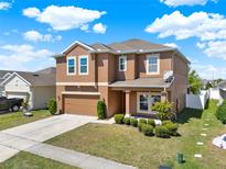 Two-story home boasts a two-car garage, neutral paint, manicured lawn and landscaping, and a driveway at 2520 Tanner Ter, Kissimmee, FL 34743