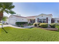 Charming single-story home featuring a well-manicured lawn, attached garage, and inviting curb appeal at 2716 Benavides Dr, The Villages, FL 32162