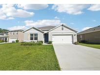 Charming single-story home featuring a well-manicured lawn and a two-car garage on a sunny day at 2916 Canary Ln, Tavares, FL 32778