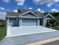 Beautiful single-story home with a spacious three-car garage and eye-catching gray color scheme at 6444 Mcknight Loop, The Villages, FL 34762