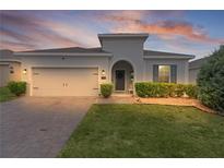 Charming home featuring a paver driveway, attached garage, and well-maintained landscaping at 916 Carmillion Ct, Groveland, FL 34736