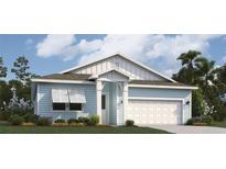 Charming one-story home featuring light blue siding, white trim, and a two-car garage for convenient parking at 987 Fiesta Key Cir, Lady Lake, FL 32159
