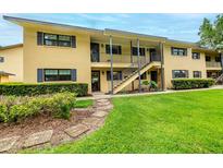 Inviting exterior of a two-story home featuring a well-manicured lawn and charming walkway at 110 N Tremain St # 205, Mount Dora, FL 32757