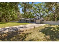 Charming single-story home with a well-manicured lawn and mature trees at 1107 Valley Rd, Fruitland Park, FL 34731