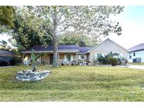 Charming single-story home featuring a well-manicured lawn and a cozy porch with decorative accents at 11312 Haskell Dr, Clermont, FL 34711