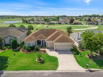 Beautiful home on a golf course featuring lush landscaping, a three car garage, and a neutral color palette at 12136 Se 176Th Loop, Summerfield, FL 34491