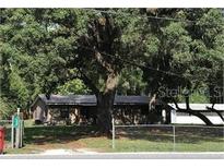 Charming single-story home with mature trees and fenced yard, offering a serene and private setting at 136 S Commercial St, Coleman, FL 33521