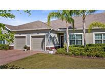 Inviting home exterior featuring a well-manicured lawn, brick driveway, and a two-car garage at 3512 Belland Cir # B, Clermont, FL 34711