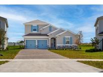 Charming two-story home featuring blue shutters, a two-car garage, and a well-maintained lawn at 5481 Marshelder St, Apopka, FL 32712