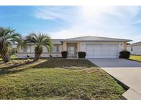 Charming single-story home with a well-maintained lawn, palm trees, and an attached two-car garage at 9857 Sw 63Rd Ct, Ocala, FL 34476