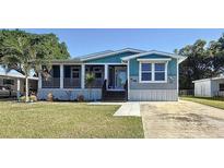 Charming single-story home featuring a covered front porch and a well-manicured lawn at 1116 Elkhart Cir, Tavares, FL 32778