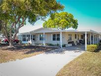 Inviting single-story home with mature trees and a covered carport at 1308 Mohawk Cir, Tavares, FL 32778