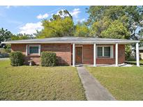 Charming brick home with a covered porch supported by classic white columns at 208 Palm Way, Tavares, FL 32778