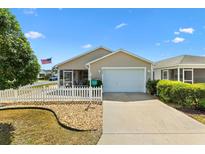 Charming single-story home with a well-manicured lawn, picket fence, and an attached one car garage at 2224 Mangrove Ln, The Villages, FL 32162