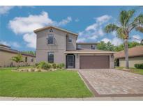 Charming two-story home with lush landscaping, brick driveway, and inviting curb appeal at 3615 Briar Run Dr, Clermont, FL 34711