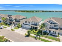 Beautiful waterfront home showcasing a well-manicured lawn, ample parking, and serene lake views at 403 Blue Cypress Dr, Groveland, FL 34736
