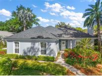 Charming single-story home with lush landscaping, manicured lawn, and a welcoming walkway at 590 Sandlake Ct, Mount Dora, FL 32757