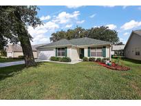 Charming single-story home featuring a manicured lawn and an attached two-car garage at 604 Juanita Ct, The Villages, FL 32159