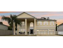 Stunning two-story home with a three-car garage, classic architectural features, and a welcoming front porch at 1454 Sterns Dr, Leesburg, FL 34748