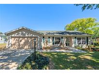 Well-maintained home with green shutters, a paved walkway and manicured landscaping at 25642 Oak Aly, Leesburg, FL 34748