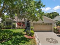 Charming single-story home with mature landscaping and a two-car garage at 25736 Whisper Oaks Rd, Leesburg, FL 34748