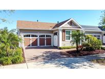 Charming single-Gathering home with a two-car garage, brick driveway, and beautifully manicured landscaping at 329 Alcove Dr, Groveland, FL 34736