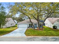 Charming single-Gathering home features mature trees, a two-car garage and beautifully landscaped front yard at 206 Desota Ct, The Villages, FL 32159