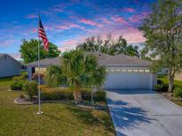 Charming single story home featuring an attached two car garage and manicured lawn at 3360 Richmond Dr, The Villages, FL 32162