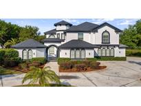 Stunning two-story home boasts a manicured lawn, beautiful landscaping, and a circular driveway at 10651 Arrowtree Blvd, Clermont, FL 34715