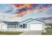 Charming home with a white picket fence and manicured lawn under a captivating sunset sky at 1723 Morelos Rd, The Villages, FL 32159