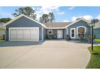 Charming single-story home features a two-car garage and inviting front porch at 2142 Margarita Dr, The Villages, FL 32159